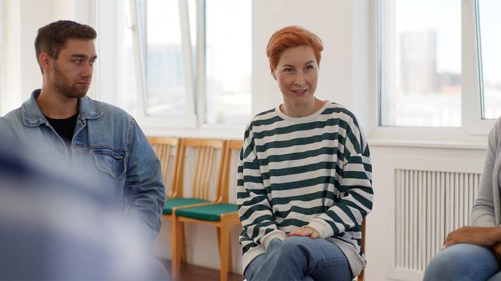 Nainen juttelee ryhmässä