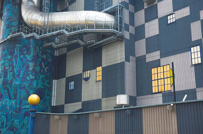 Sininen rakennus, jossa suuret metalliset putket kiertävät ulkoseinällä.