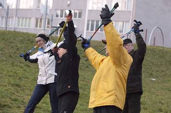 Kuvassa on ikääntyneitä harrastamassa ulkojumppaa ohjaajan vetämänä. På bilden syns äldre personer som deltar i utomhusgymnastik under ledning av en instruktör.