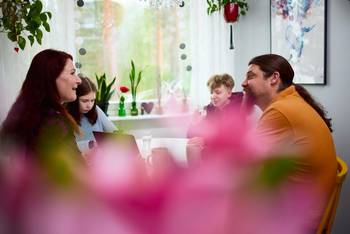 Perhe pöydän ympärillä