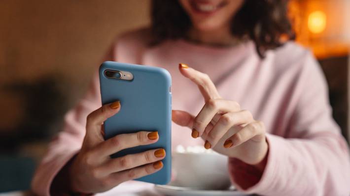 Nainen käyttää älypuhelintaan. En kvinna använder sin mobiltelefon.